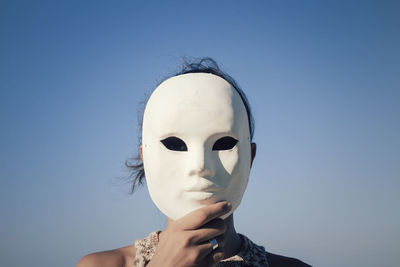 Close-up of woman with mask against sky