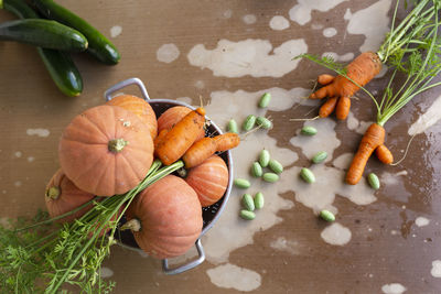 Close-up of freshly harvested organic pumpkins, zucchinis, carrots and pickles on a table.