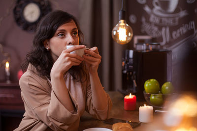 Young woman having food at home