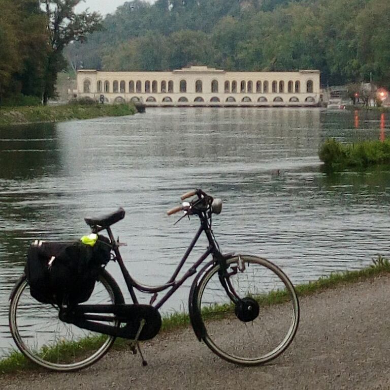 BICYCLE BY RIVER AGAINST BRIDGE