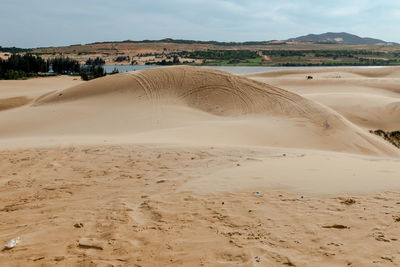 Sand dunes in desert against sky