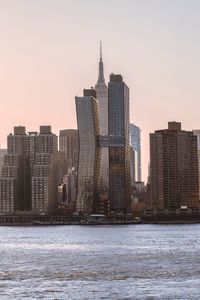 Modern buildings in city against sky during sunset