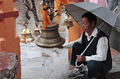 Reflection of man in mirror while standing outdoors