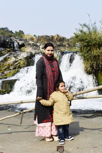 Mother and daughter near a waterfall