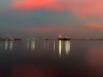 Illuminated sea against sky during sunset