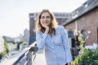 Businesswoman standing on her urban rooftop garden