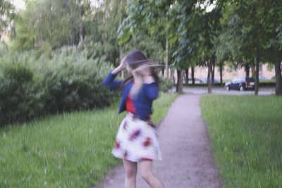 Rear view of girl walking on grass