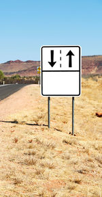 Information sign on field against clear blue sky