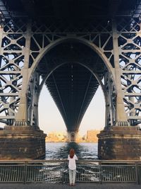 Rear view of woman standing on bridge
