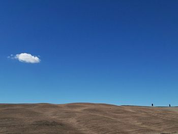 Scenic view of desert against blue sky