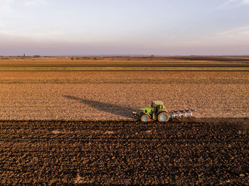 Serbia, vojvodina. tractor plowing field in the evening