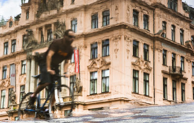 Man walking on street by buildings in city