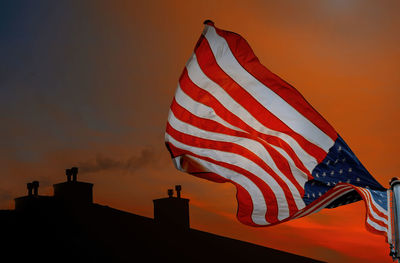 Low angle view of flag against sky during sunset