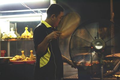 Side view of man working indoors