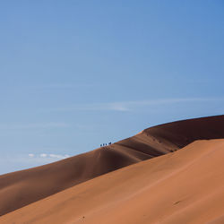 Sand dunes in desert against sky