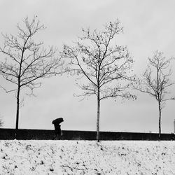 Man standing on snow covered field against sky