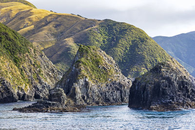 Scenic view of mountain by sea against sky