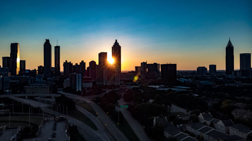 Aerial view of buildings in city during sunset