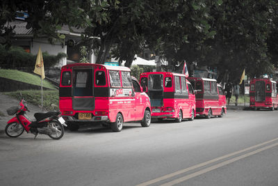 Vehicles on road against trees in city