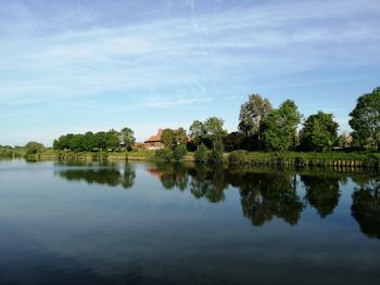 Scenic view of lake by trees against sky