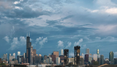 Modern buildings in city against cloudy sky