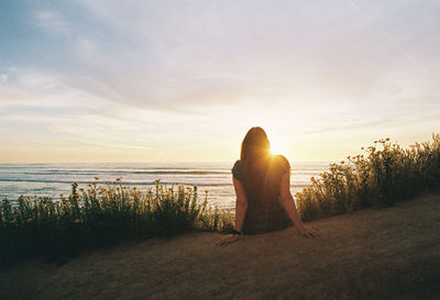 Rear view of woman looking at sea against sky