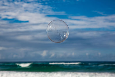 Bubbles over sea against sky