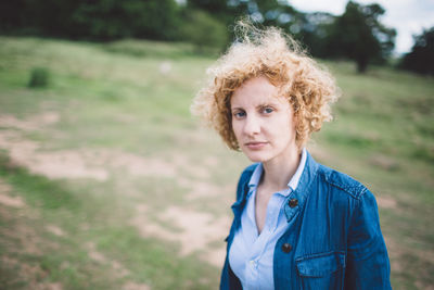 Portrait of young woman standing on field