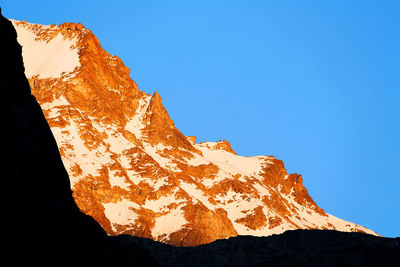 Low angle view of rocky mountain during winter at gran paradiso national park