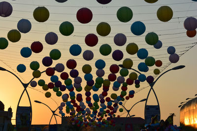 Multi colored hot air balloon flying against sky at sunset