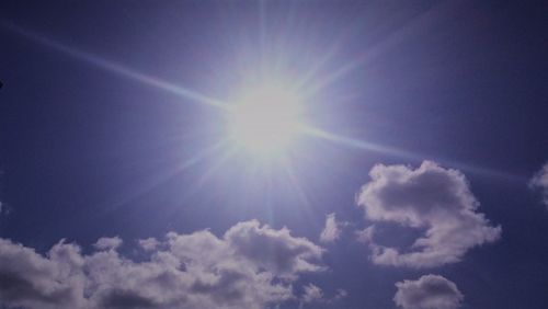 Low angle view of bright sun in sky