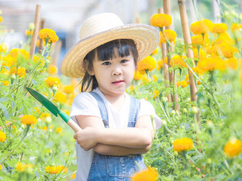 Portrait of cute girl standing amidst flowers