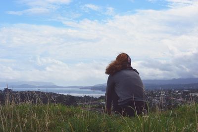 Rear view of woman on landscape against sky