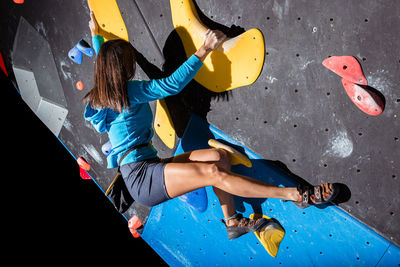 Athletic girl climbing on an indoor climbing wall