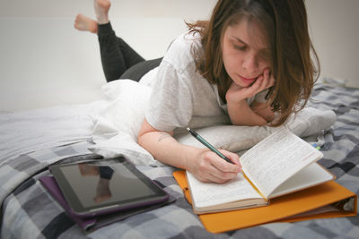 Midsection of woman reading book on table