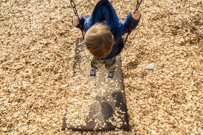 High angle view of boy on swing