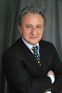 Portrait of businessman standing against wall