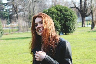 Close-up of beautiful woman standing on grassy field