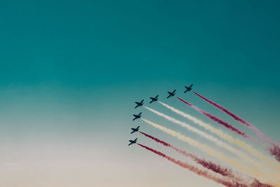 Low angle view of airshow against clear sky
