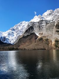 Scenic view of lake and snowcapped mountains against sky