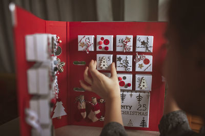 Cropped hand of girl holding christmas decoration