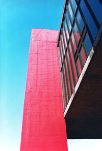 Low angle view of pink building against blue sky