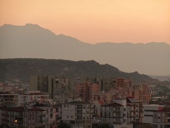 Townscape against sky at sunset