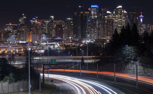 High angle view of car light tails against cityscape at night