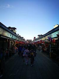 Group of people in market against clear sky