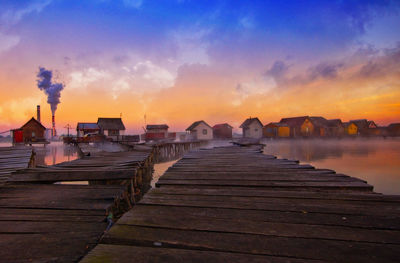 Pier over sea against sky during sunset