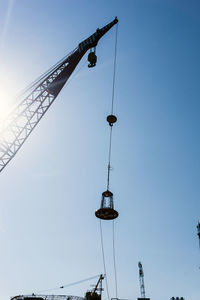 Low angle view of crane against clear sky