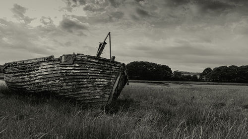 Old barn on field against sky