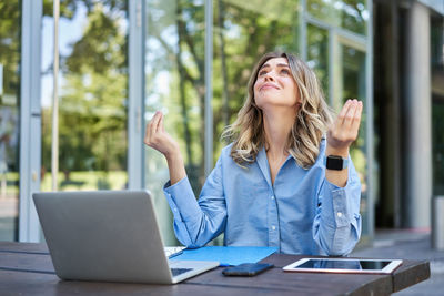 Businesswoman using laptop while sitting on table