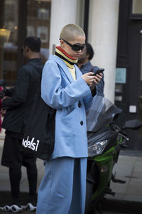 Man using mobile phone on street in city